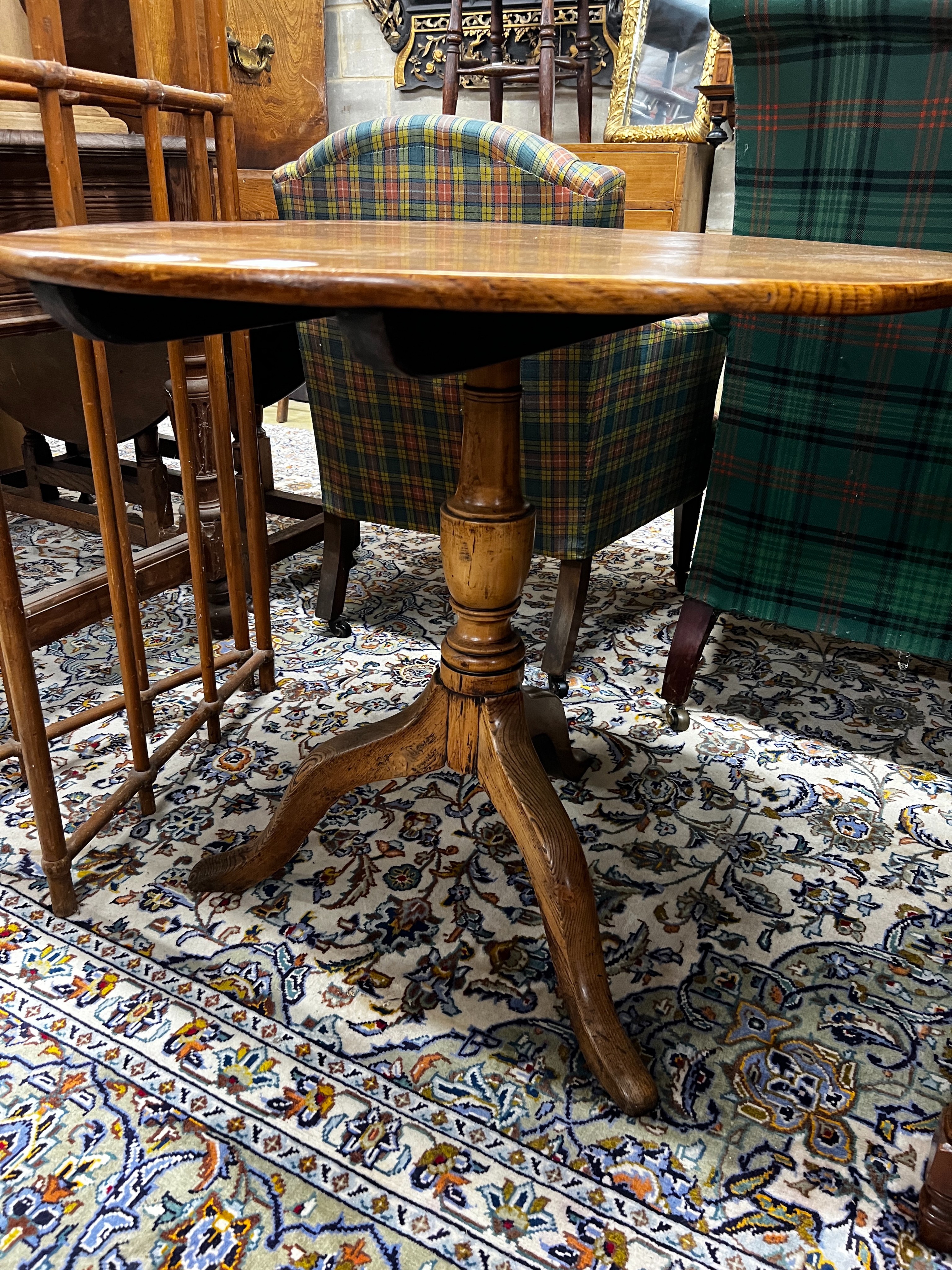 A George III circular oak tilt top tripod tea table, diameter 80cm, height 75cm